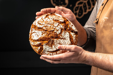 male hands holding corn bread with powder in a freeze motion of a cloud of powder midair. Hands kneading raw dough. Culinary, cooking, bakery concept