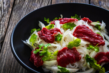Pho soup - Vietnamese soup with beef on wooden table
