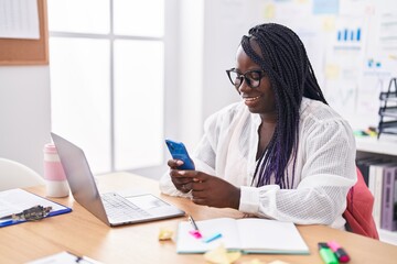 African american woman business worker using laptop and smartphone at office