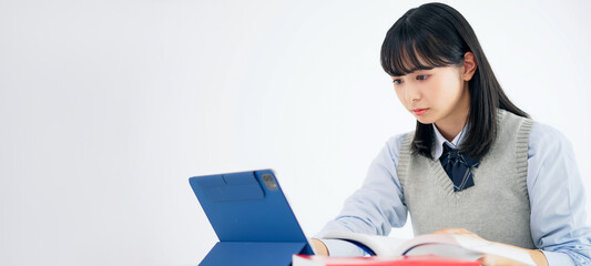 タブレットを見ながら勉強する女子学生