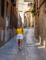 Fototapeta na wymiar Young woman tourist enjoying and exploring the medieval city of Toledo in Spain
