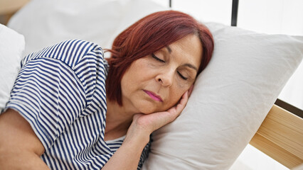 Middle age woman lying on bed sleeping at bedroom