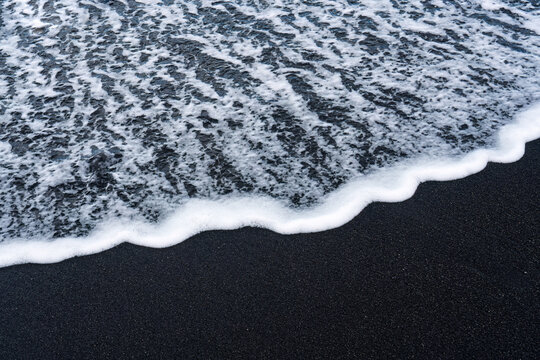 Sea wave on volcanic black sand beach in Diamond beach