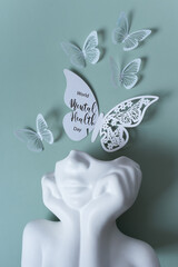 Plaster head with butterflies on a colored background. Mental health concept. World mental health...