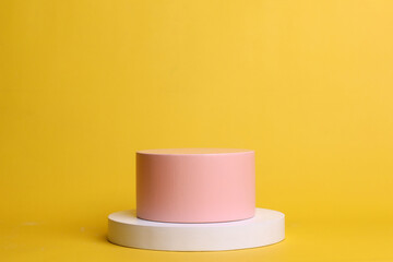 Soft pink podium and white cylinder in yellow pastel color. Platform for cosmetic presentation or beauty products. 