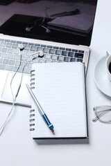 Modern style of working desk with computer screen, keyboard, earphone and blank notebook. Top view, flat lay