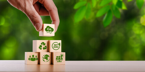 concept of carbon credit reducing carbon emissions Zero net greenhouse gas emissions target Carbon credits to invest in sustainable businesses green climate investment wooden block with green icon - obrazy, fototapety, plakaty