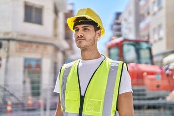 Young hispanic man architect standing with relaxed expression at park