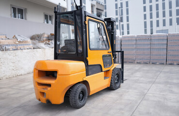 Parking forklift in logistics warehouse. Pallet stacking equipment outside and modern warehouse storage concept