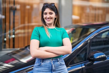 Young hispanic woman smiling confident standing with arms crossed gesture at street