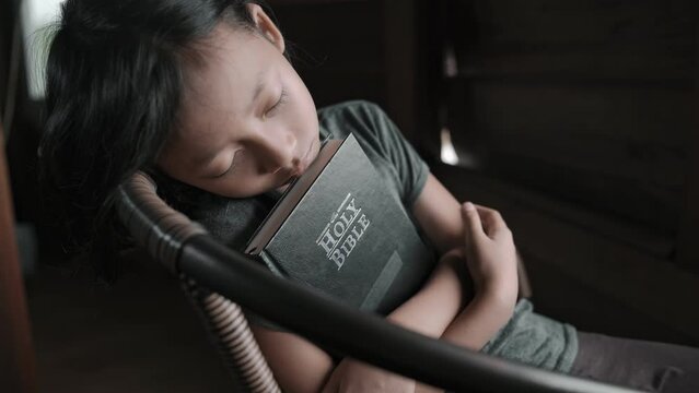 Child girl holding and reading Bible on tablet. High quality 4k video.