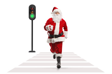 Full length shot of santa claus running at a pedestrian crosswalk - obrazy, fototapety, plakaty