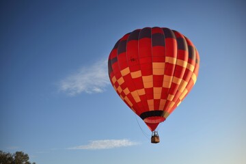 Naklejka premium A colorful hot air balloon soaring through a clear blue sky