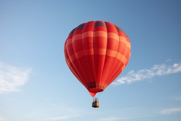 Naklejka premium A vibrant red hot air balloon soaring through a clear blue sky