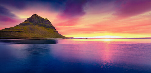 Panoramic summer view of Kirkjufell mountain. Exciting sunset on Snaefellsnes peninsula with fall of tide in Atlantic ocean, Iceland, Europe. Beauty of nature concept background..