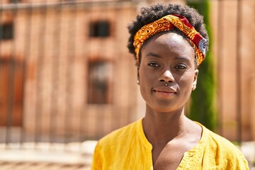 Young african american woman with relaxed expression standing at street