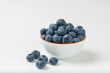 Clouse up of ripe blueberries in a white bowl isolated on white background