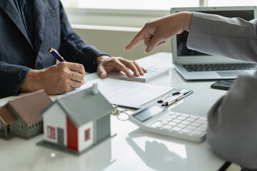 The real estate agent forms a home with the agent and the client discusses the contract to...