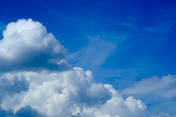 Fluffy white clouds float in the expansive blue sky on this beautiful summer day.