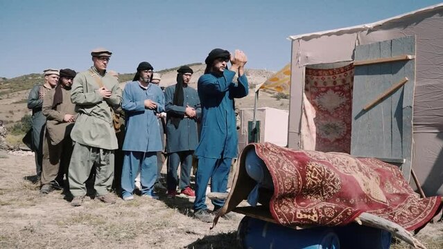 Muslim funerals during the war in Afghanistan. Pashtun men stand.