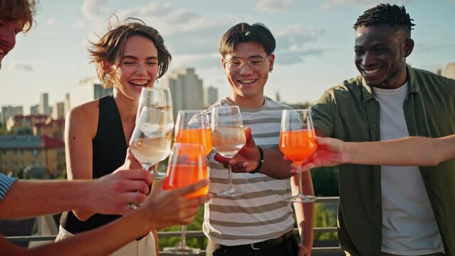 Carefree young people having party on terrace with drinks