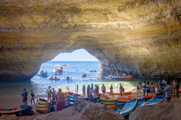 Fototapeta na wymiar Children, enjoying Benagil, Portugal. Benagil Cave inside Algar de Benagil, famous sea cave in Algarve coast, Lagoa.