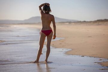 Happy children, boys, playing on the beach on sunset, kid cover in sand, smiling, laughing