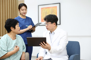 Fototapeta premium 병원에서 의사와 간호사와 환자가 회진 중 진료 상담하는 모습