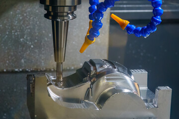 The CNC milling machine cutting injection mold part by solid ball end mill tool in the light blue scene. © Pixel_B