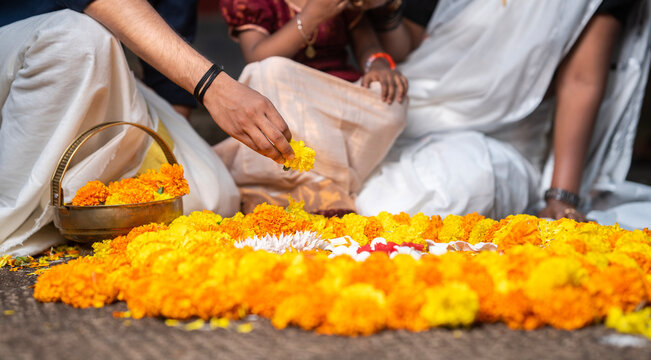 Kerala Onam festival image, Indian family making Onam Pookalam with flowers