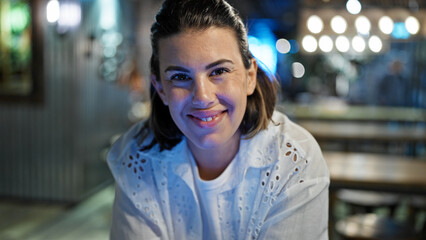 Fototapeta premium Beautiful young hispanic woman smiling confident at cafeteria