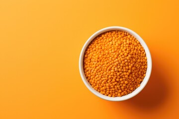 Lentils in bowl on orange colour background.