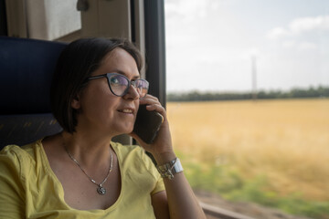 Phone call, travel and woman talking on the train, chatting or speaking to contact in lobby. Communication, mobile and happy female with smartphone for networking while traveling by train