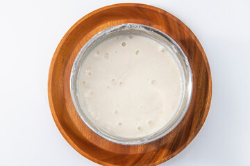 Selective focused image of fermented batter for idli and dosa in an isolated background. Idly and...