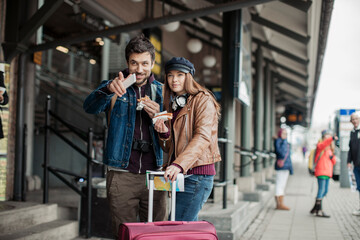 Young caucasian couple traveling and waiting for their bus at the bus station