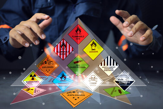 Hazardous substance concept chemical safety officer at a dangerous goods warehouse work through hologram to arrange warning sign for different chemical to separate area in sea and air cargo shipment