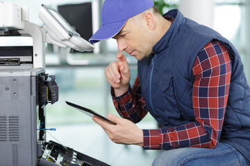 closeup shot young male technician repairing digital photocopier machine