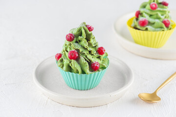Christmas cupcakes in the form of a Christmas tree with cranberries on a table. Vegan, gluten, lactose, sugar free.