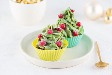 Homemade Christmas green cupcakes in the form of a Christmas tree with cranberries. Vegan, gluten, lactose, sugar free.