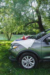 outdoors picnic pizza with drink on car hood at the river side