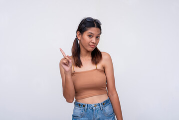 A young asian woman waving her finger, saying no, declining an offer. Isolated on a white...