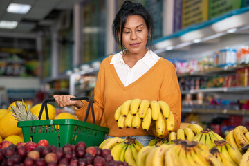 Brazilian woman evaluates quality of banana in hortifruti