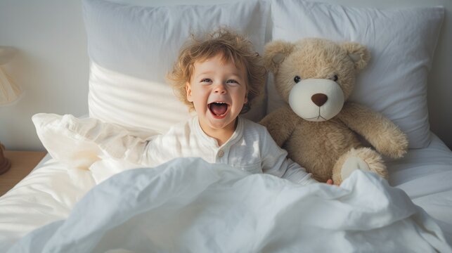 A toddler in white pajamas playing in bed in the morning with teddy bear. AI generative.