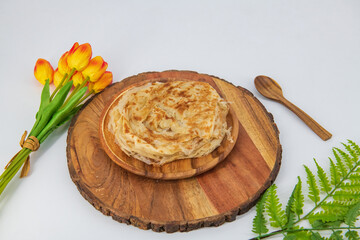 Malabar parota in an isolated background. South Indian Porata in a wooden plate and decorated and isolated. Also called nool porata, Roti Parata