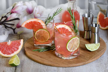 Pink Paloma cocktail redRefreshing organic cocktail with grapefruit slice, lime and rosemary sprig in a glass grapefruit with tonic