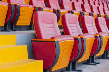 seats of red tribune on sport stadium with empty outdoor arena