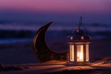Islamic concept image, Crescent moon shape with Ramadan lantern lamp on the beach, Eid Mubarak poster image