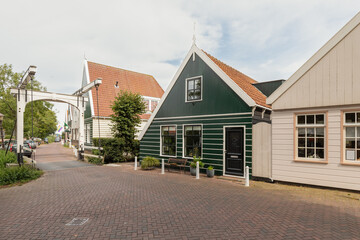 Narrow street with traditional painted wooden houses in the picturesque village of Ransdorp near Amsterdam.