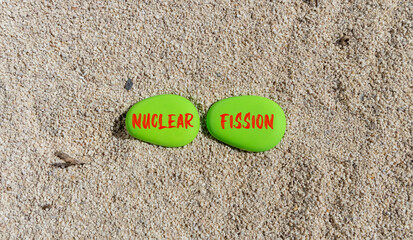 Fototapeta na wymiar Nuclear fission symbol. Concept words Nuclear fission on beautiful green stone. Beautiful sand beach background. Business science nuclear fission concept. Copy space.