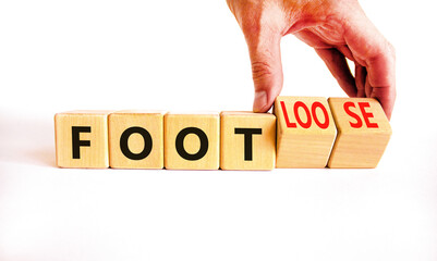 Foot or footloose symbol. Businessman turns wooden cubes and changes word Foot bad to Footloose. Beautiful white table white background. Business foot or footloose concept. Copy space.